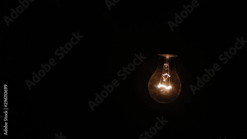 Close-up ordinary electric lamp hanging and swinging in dusty and smoky rusty and dirty basement bunker, like bomb shelter, huge spider web in foreground