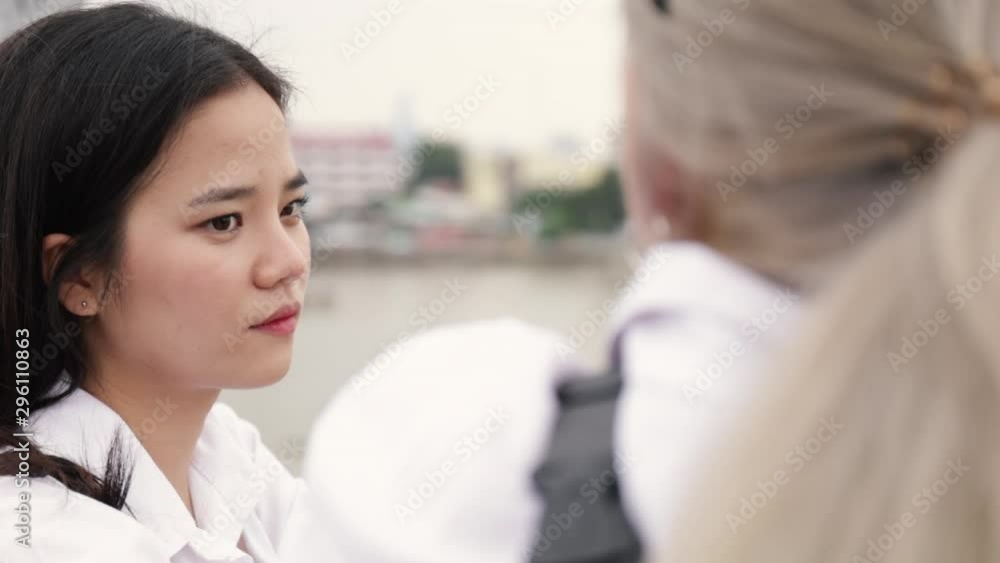 Asian lesbian couple talking while standing on the bridge. Beautiful Asian women traveling with girlfriends lifestyle holiday. Asian lesbian couple talking while standing on the bridge. Beautiful Asian women traveling with girlfriends lifestyle holiday.