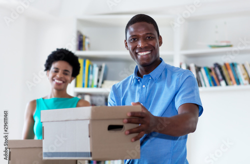 African american couple with boxes at new home