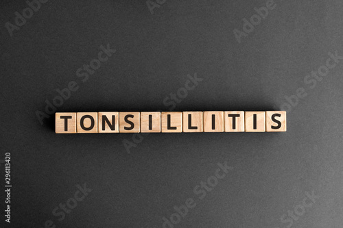 Tonsillitis - word from wooden blocks with letters, tonsils inflammation pharyngitis tonsillitis concept,  top view on grey background