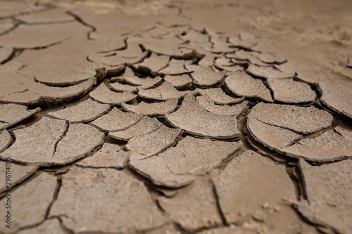 side view of natural background with sand texture covered with cracks and exfoliated parts from the drought