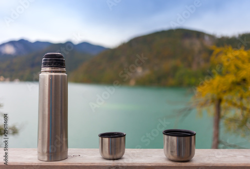 Pause im Freien, Thermoskanne und Becher auf Holzbrett