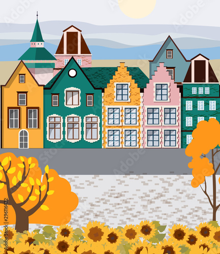 Old retro town with colorful buildings and cobblestone paved road in front. A...