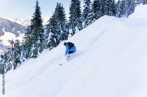 Photo of sporting man riding snowboard on snowy slope