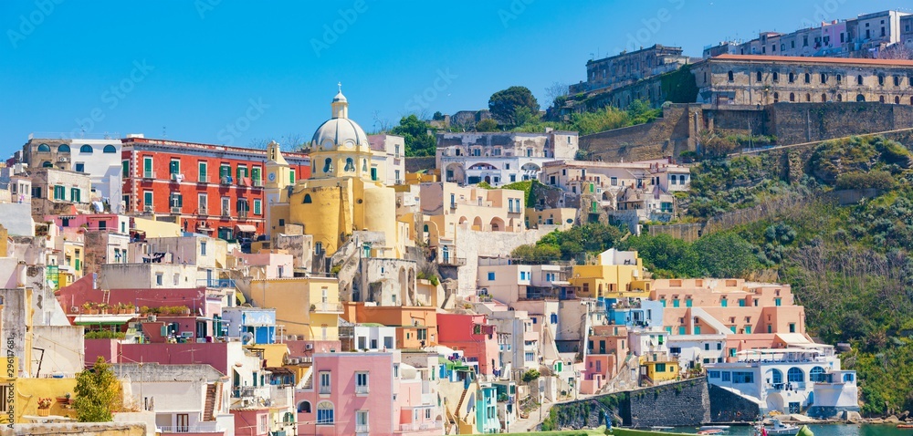 Colorful vibrant houses on Marina Corricella in sunny day in Procida Island, Italy.