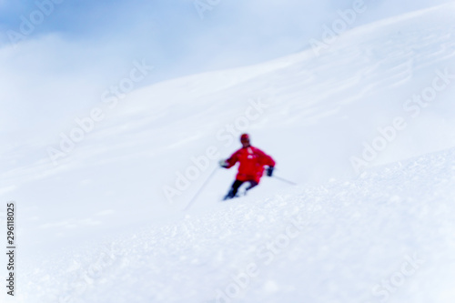Defocused photo of sporting man skiing on snowy slope.
