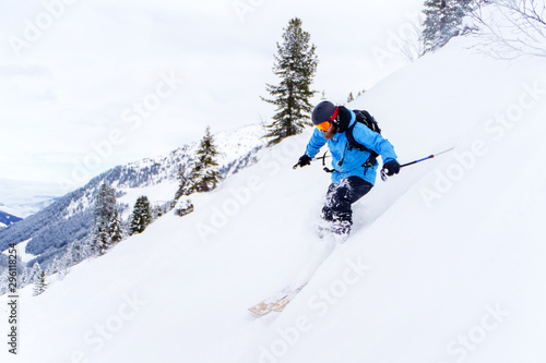 Image of sports man with beard skiing in winter resort