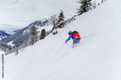 Photo from back of athlete man with red backpack skiing