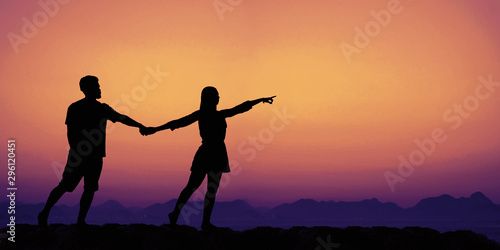 Pointing couple on sunset with copy space