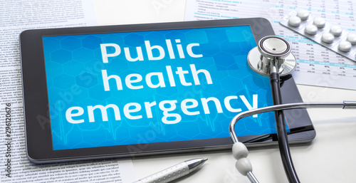 The word Public health emergency on the display of a tablet photo