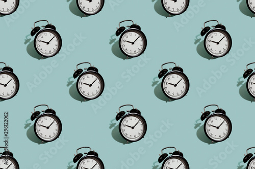 Many black classic style alarm clock isolated on green background