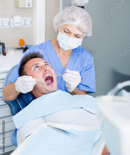 Female dentist with male patient during   heckup