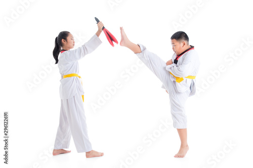 Two young asian children having taekwondo training ,one boy kicking while other one girl holding kick target over white background.