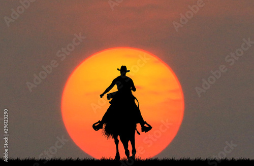 silhouette cowboy riding a horse on sunrise