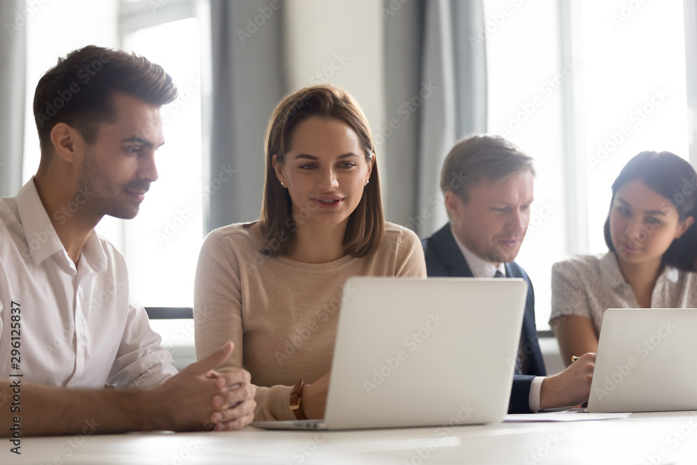 Businesswoman mentor teaching new employee, looking at laptop screen Businesswoman mentor teaching new employee, looking at laptop screen