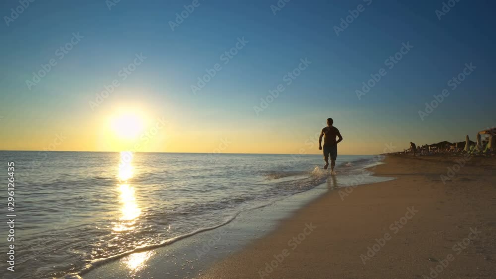 Young active man running on the beach at sunset for healthy lifestyle and wellness Young active man running on the beach at sunset for healthy lifestyle and wellness