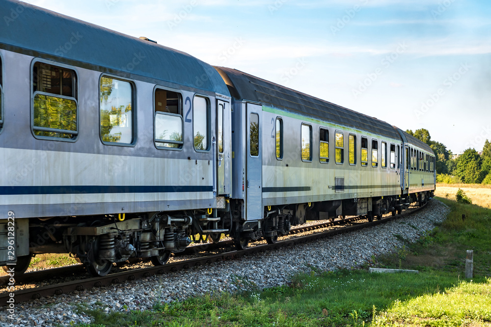 passenger train rides among fields on a sunny day