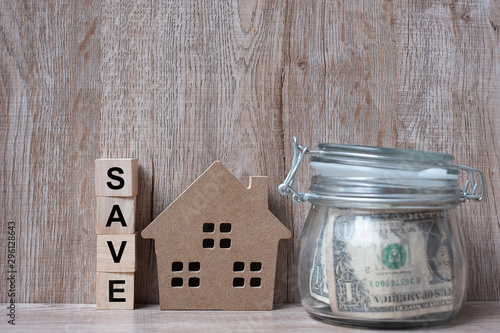 Wood house model and money glass jar, American dollar banknote. real estate, Property investment, home mortgage financial and savings concepts