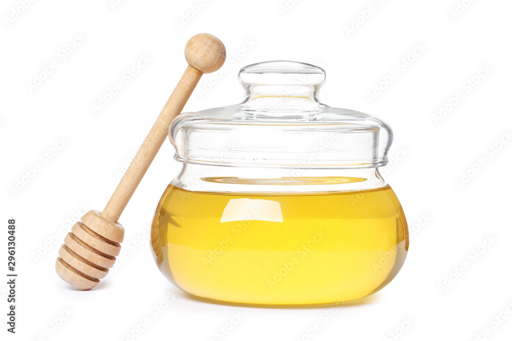glass jar full of honey and dipper isolated on white background glass jar full of honey and dipper isolated on white background
