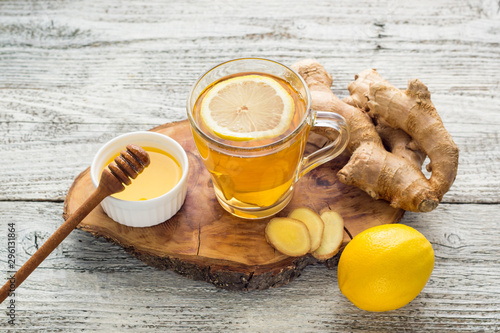 Ginger tea with lemon and honey on a white wooden background. Hot healthy winter drink