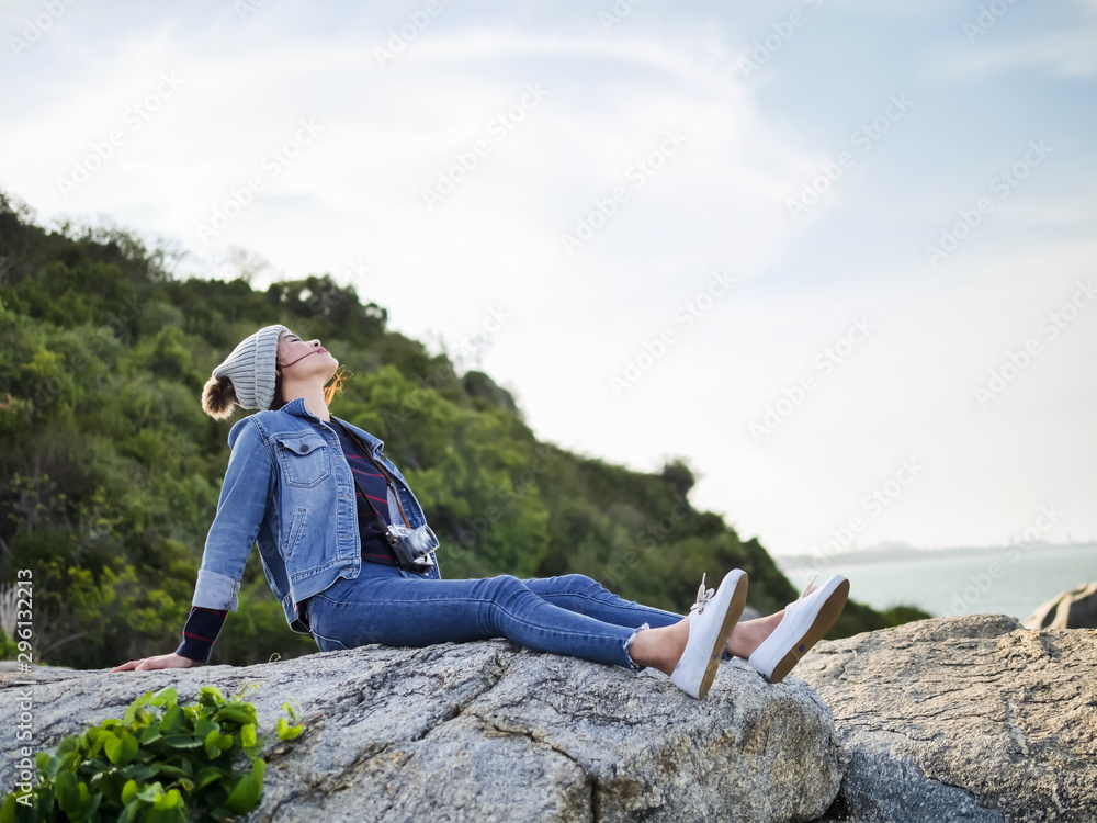 Asian woman relaxing on cliff facing to seaview, lifestyle concept.