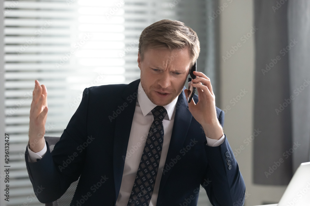 Unhappy angry businessman talking on phone, solving business problem Unhappy angry businessman talking on phone, solving business problem