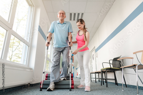 Fotografia Seniors in rehabilitation learning how to walk with crutches