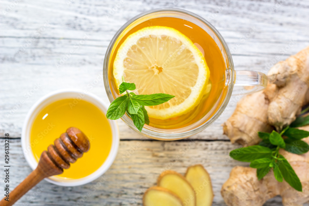 Ginger tea with lemon mint and honey on a white wooden background. Hot healthy winter drink Ginger tea with lemon mint and honey on a white wooden background. Hot healthy winter drink