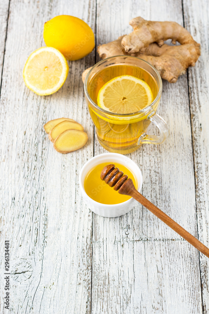 Ginger tea with lemon and honey on a white wooden background. Hot healthy winter drink Ginger tea with lemon and honey on a white wooden background. Hot healthy winter drink