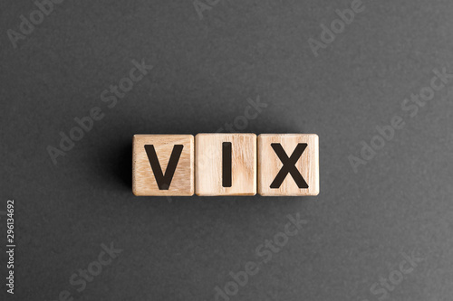 VIX - acronym from wooden blocks with letters, Volatility Index VIX concept,  top view on grey background photo