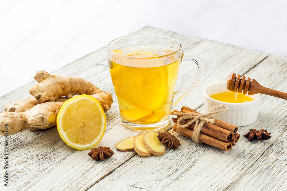 Autumn hot drink tea with ginger, lemon, honey and spices on white wooden background Autumn hot drink tea with ginger, lemon, honey and spices on white wooden background