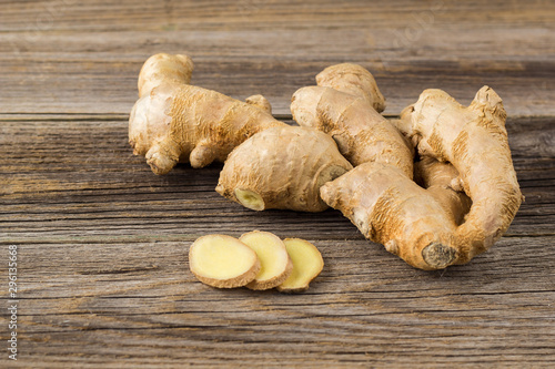 Fotografie, Obraz A root of ginger with sliced pieces on a wooden background