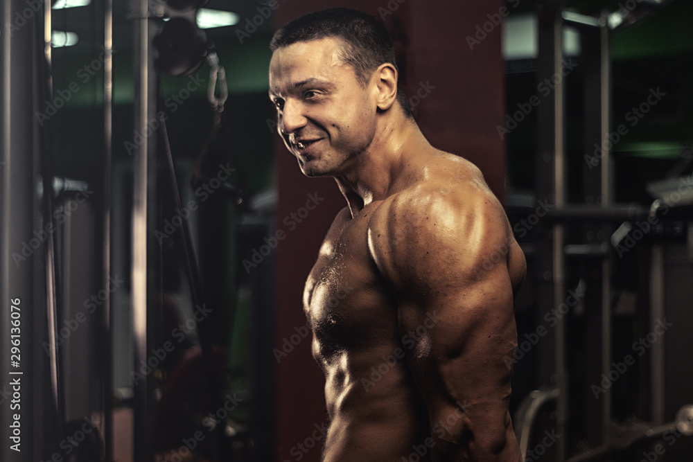 muscular bodybuilder doing exercise on bars in the gym. a handsome, sporty, sexy guy with a abs training in the gym. fitness, bodybuilding, nutrition, healthy lifestyle muscular bodybuilder doing exercise on bars in the gym. a handsome, sporty, sexy guy with a abs training in the gym. fitness, bodybuilding, nutrition, healthy lifestyle
