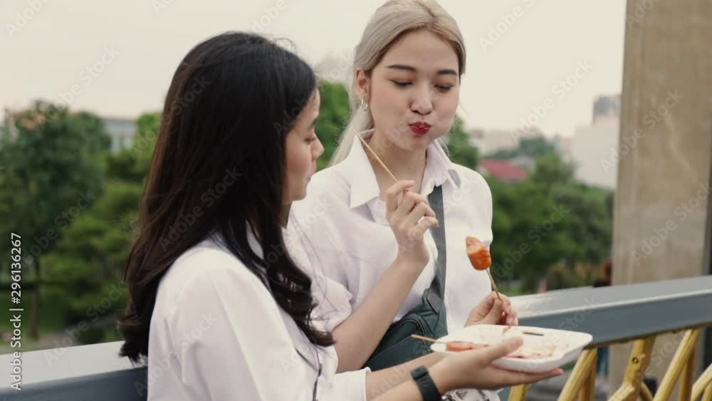 Asian lesbian couple enjoying traveling in Thailand and eating meatball having fun during vacation time. LGBT concept. Видео Stock | Adobe Stock