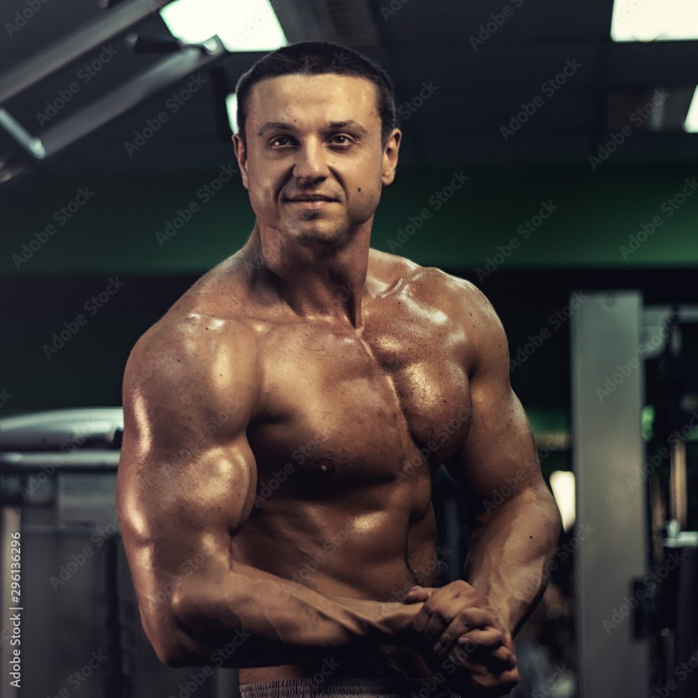 muscular bodybuilder doing exercise on bars in the gym. a handsome, sporty, sexy guy with a abs training in the gym. fitness, bodybuilding, nutrition, healthy lifestyle muscular bodybuilder doing exercise on bars in the gym. a handsome, sporty, sexy guy with a abs training in the gym. fitness, bodybuilding, nutrition, healthy lifestyle