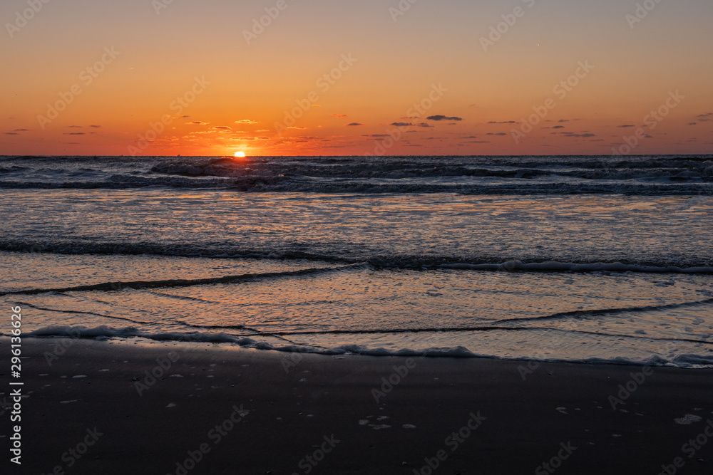 Beautiful sunset landscape at the North sea and orange sky with awesome sun golden reflection on waves as a background. Amazing summer sunset view on the beach. Beautiful sunset landscape at the North sea and orange sky with awesome sun golden reflection on waves as a background. Amazing summer sunset view on the beach.