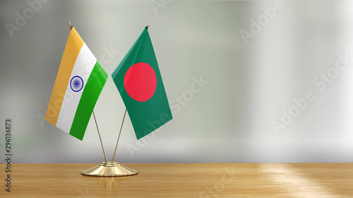 Bangladesh and Indian flag pair on a desk over defocused background 