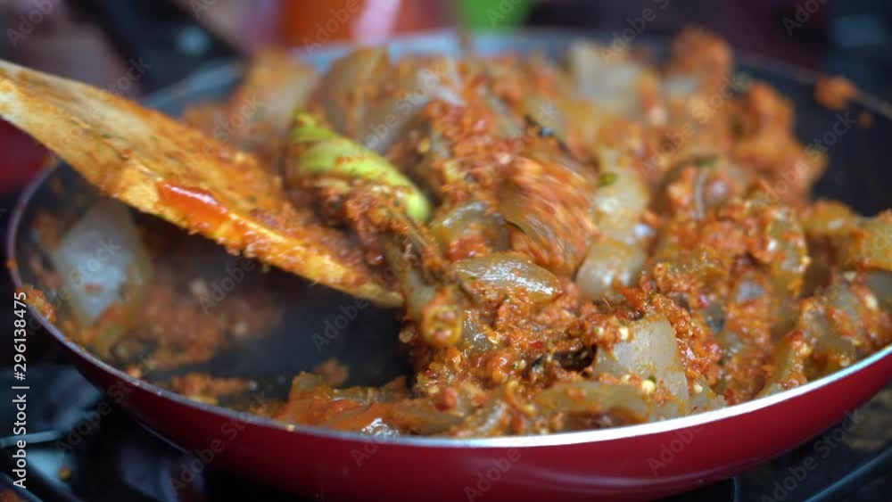 Frying pan with onion, beef stomach, red pepper and sauce, close up. Indonesia. Indonesian cuisine, spicy beef stomach meet and sauce garnish with lemongrass leaf and red chili. Cooking food Frying pan with onion, beef stomach, red pepper and sauce, close up. Indonesia. Indonesian cuisine, spicy beef stomach meet and sauce garnish with lemongrass leaf and red chili. Cooking food