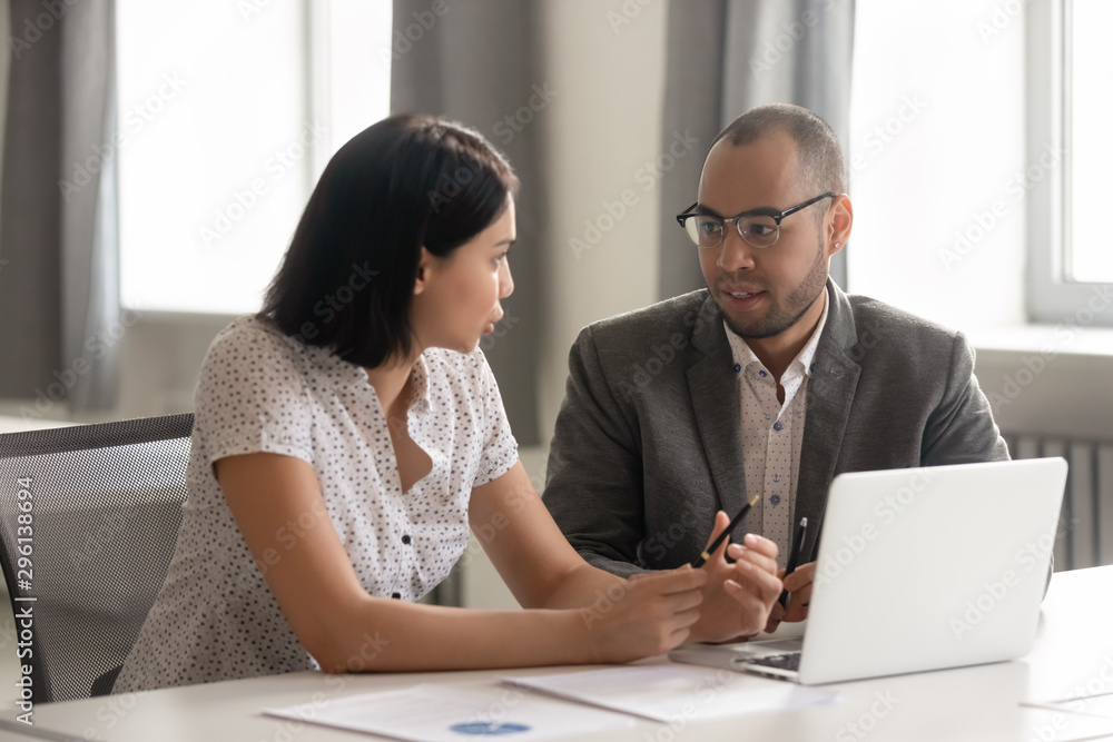 Obraz premium African American businessman and Asian businesswoman discussing project