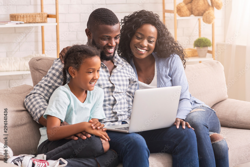 African american family of three using laptop together at home