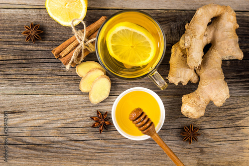 Autumn hot drink tea with ginger, lemon, honey and spices on wooden background