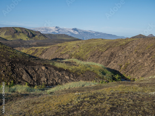 Icelandic landscape with eyjafjallajokull glacier tongue, blue river stream and green hills. Fjallabak Nature Reserve, Iceland. Summer blue sky