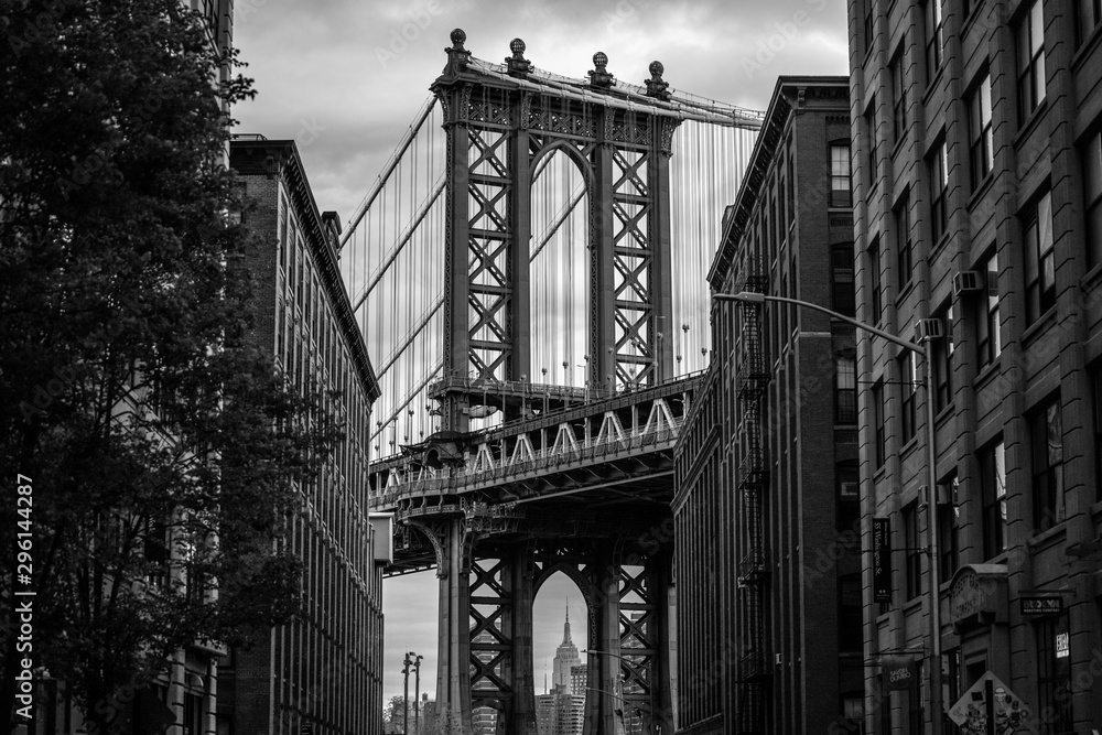 View of one of the towers of the Manhattan Bridge from the streets of the DUMBO district, Brooklyn, NYC black and white