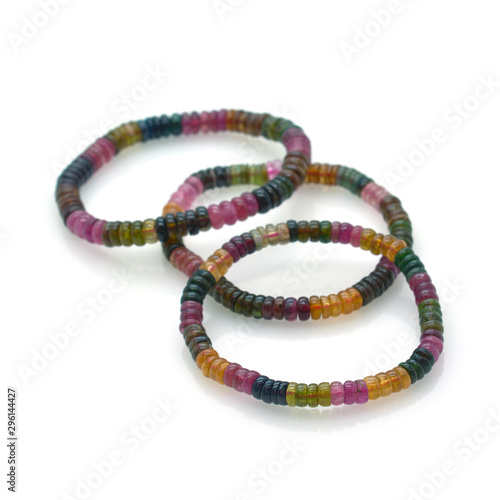 Three tourmaline bracelets of different colors on white isolated background