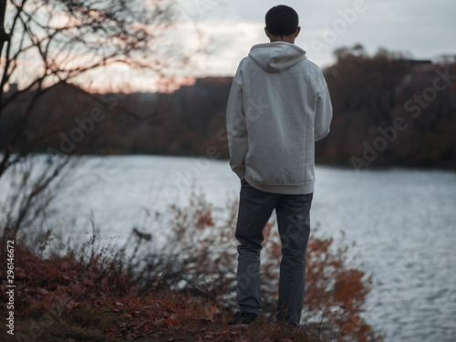 a lonely man stands on the Bank of the river. cloudy and gloomy autumn cold weather. depression and loneliness