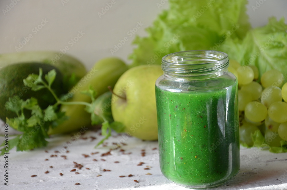 Detox diet. Green smoothie with different vegetables on white wooden background copy space. diet vegitarians healthy low calorie food. salad, greens, green apple chia or flax linen seeds Detox diet. Green smoothie with different vegetables on white wooden background copy space. diet vegitarians healthy low calorie food. salad, greens, green apple chia or flax linen seeds