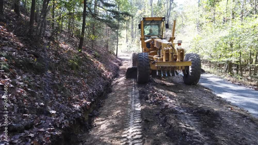 Front of road grader as it crowns a dirt road for water runoff. Front of road grader as it crowns a dirt road for water runoff.
