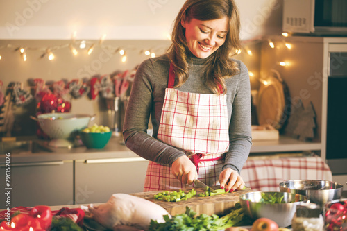 Young Woman Cooking in the kitchen. Healthy Food for Christmas (stuffed duck or Goose)