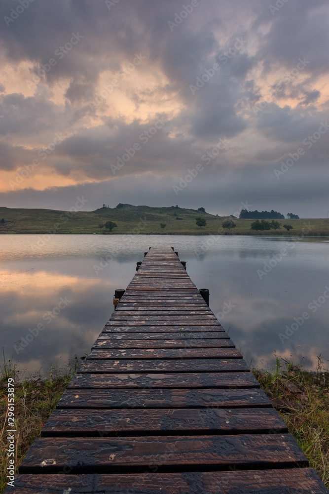 Obraz premium Landscape of a jetty on a dam with dramatic clouds of rain storm