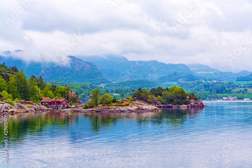 Beautiful landscape of the fjord Lysefjord in Norway. A small traditional Scandinavian village on the picturesque coast of the fjord between the mountains. Travel background